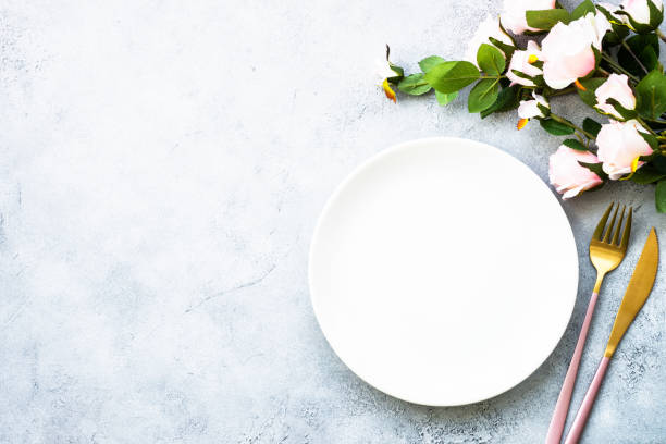 istock Table setting with white plate, cutlery and flowers. 1987873349