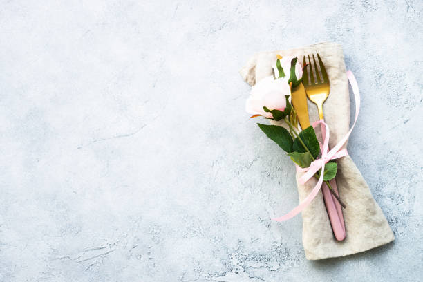Spring Table setting with modern cutlery and rose flowers.