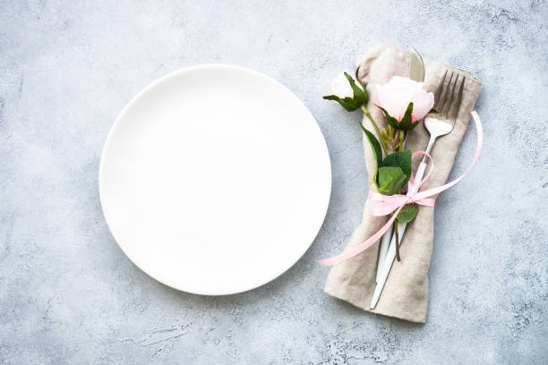 istock Table setting with white plate, cutlery and flowers. 1987873509