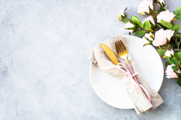istock Table setting with white plate, cutlery and flowers. 1987874383