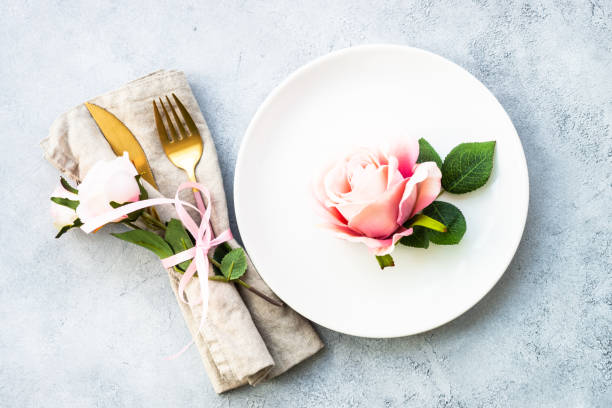 istock Table setting with white plate, cutlery and flowers. 1987874404