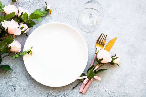 istock Table setting with white plate, cutlery and flowers. 1987874411
