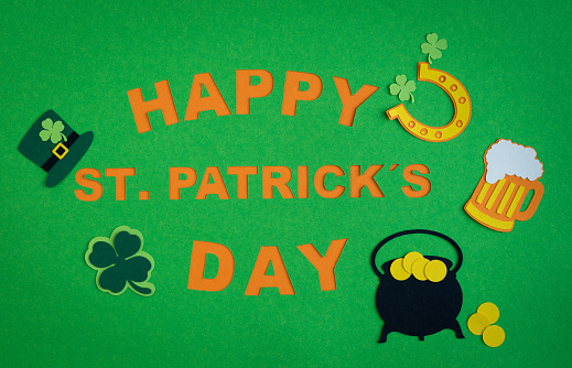 St. Patrick's Day. Banner design on green background with HAPPY ST. PATRICKS DAY and ornaments of beer, horseshoe, shamrock and pot with gold. Copy space.