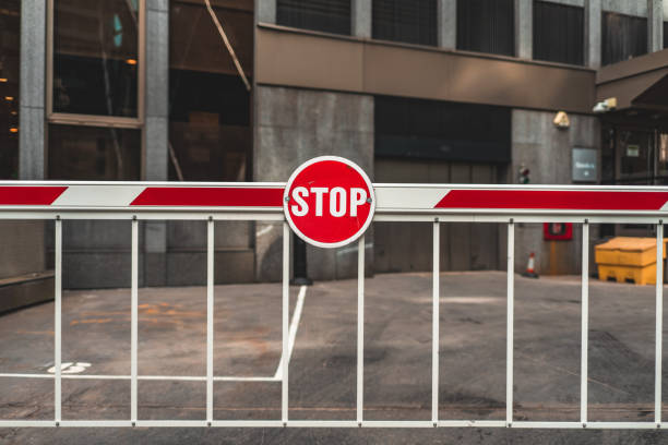 red round stop sign on an entrance gate on a parking lot - boundary parking security barrier gate fotografías e imágenes de stock