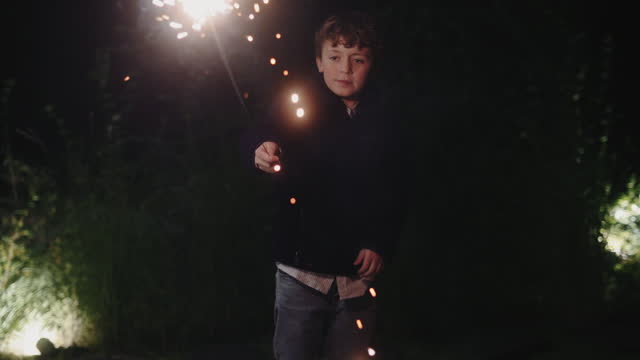 Happy boy with sparkler spinning