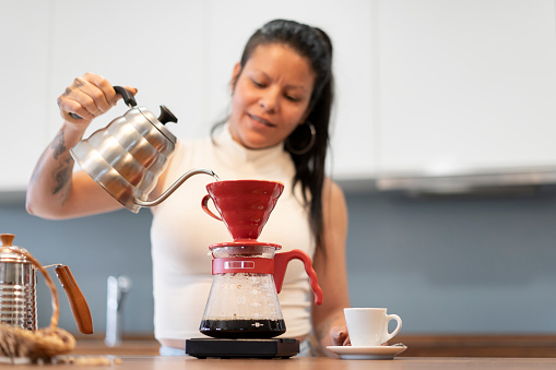 Mature woman preparing coffee at home