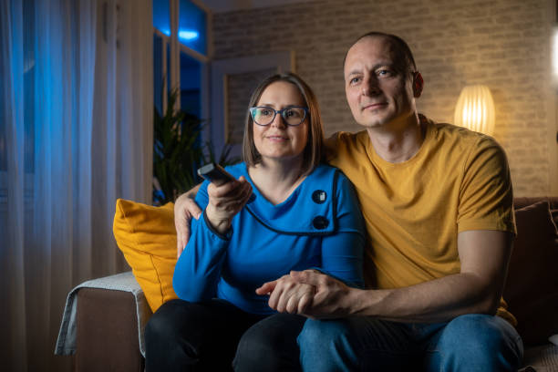 istock Couple relaxing on the couch at home watching TV 1987999433