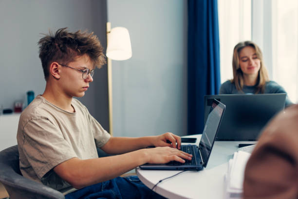 istock Teenagers homeschooling using laptops and modern technology to learn 1988023052