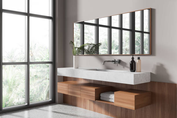 istock Stylish hotel bathroom interior with sink, accessories and window 1988064960