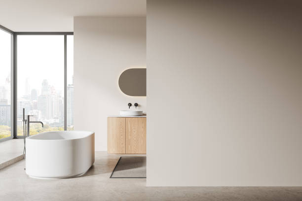 istock Beige bathroom with tub, sink and blank wall 1988071271