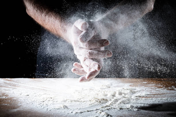 istock Closeup of backer's hands on the work bench with flour 1988074451