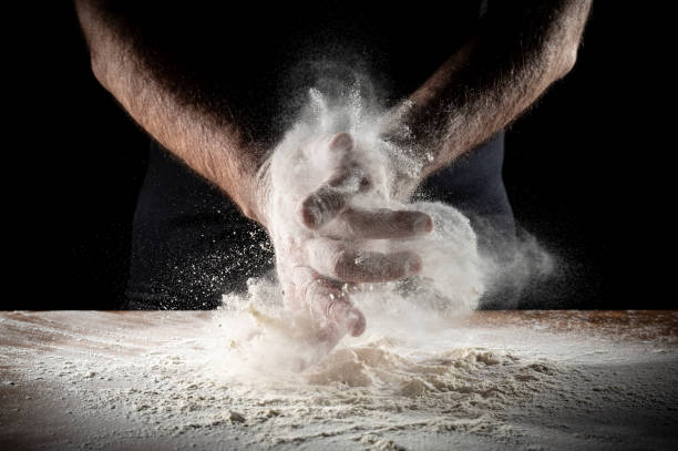 istock Closeup of backer's hands on the work bench with flour 1988074452