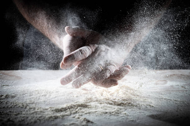istock Closeup of backer's hands on the work bench with flour 1988074455