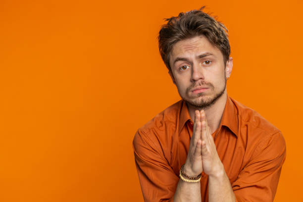 istock Caucasian sad man praying making wish, asking hopeful help, begging apology, meditation, imploring 1988077846