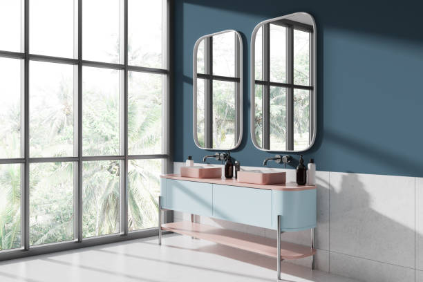 istock Colorful hotel bathroom interior with double sink and mirrors, window 1988078400