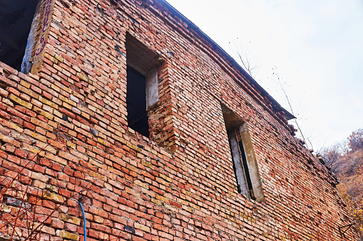 an old abandoned brick house with windows without frames