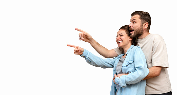 Isolated happy heterosexual couple pointing fingers on promotional product.