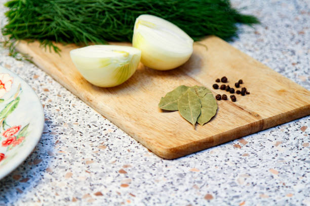 istock Onion Cut in Half. Black Pepper and Dry Bay Leaf. 1988189067