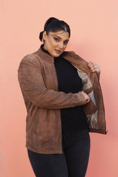 A woman in brown Leather jacket and black top