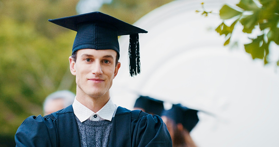 Student man, graduation and outdoor for portrait with pride, achievement or success at college for celebration. University graduate, person and event for ceremony with scholarship, campus and park