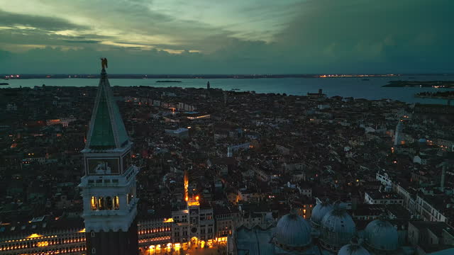 4K Aerial view Real time Footage top view of Piazza San Marco with Basilica di San Marco and Crowd of People Tourist walking and sightseeing in city's main public square at night time, Venice, Italy