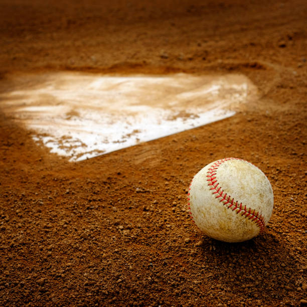 istock Old Leather Baseball on Field by Home Plate or Base 1988227309