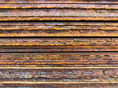 Rusty sheets of metal are on top of each other