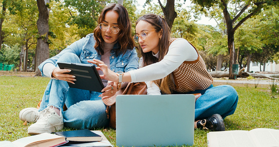 Woman, student and friends with tablet at park for research, education or outdoor learning together. Female person or learners on technology for online search, social media or communication in nature