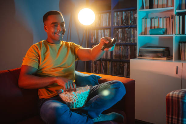 istock Young man watching TV at night 1988263525