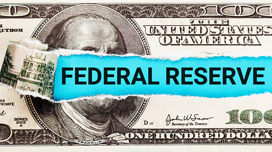 Federal Reserve. The word Federal Reserve in the background of the US dollar. Building Exterior with American Flag. Iconic Symbol of Monetary Policy and Central Banking System in the USA.