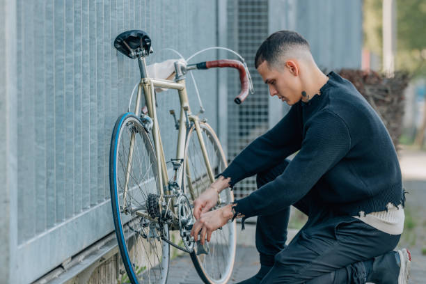 istock young man on the street fixing the bicycle 1988269217
