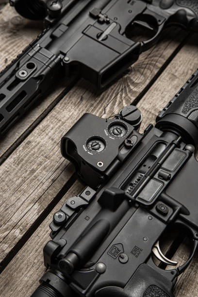 istock A carbine with red dot sight. Weapons for police, special forces and the army.  Modern automatic rifle on a wooden background. 1988286132