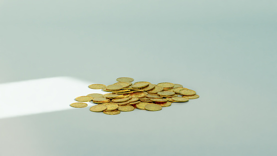 a pile of gold coins on a white surface