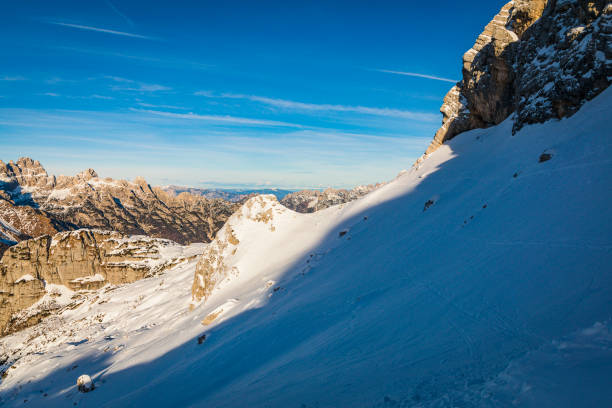 SELFIE: Fearless snowboarder descends a steep snowy mountain in picturesque Albanian Alps. He enjoys riding challenging untouched terrains among snowed mountaintops during an adventure winter trip.