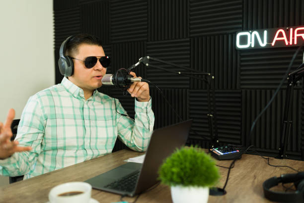istock Handsome man in the recording studio doing a radio show or podcast 1988302529