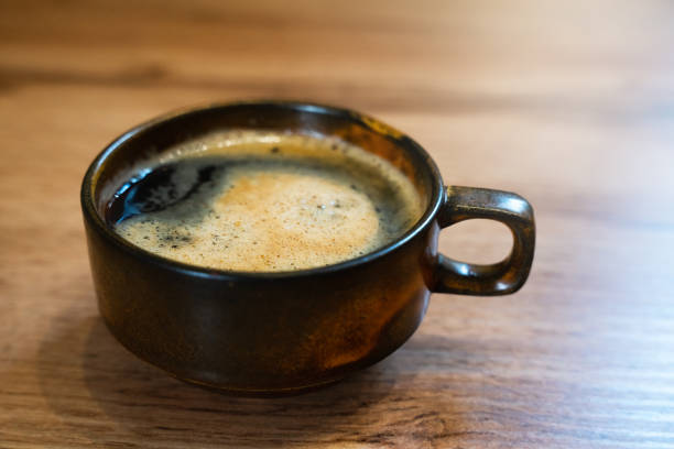 istock A cup of fragrant fresh coffe on wooden table at cafe. Close-up. Selective focus. 1988303063