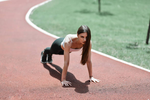 Beautiful Female Staying Focused On High Plank Form While Exercising In Park