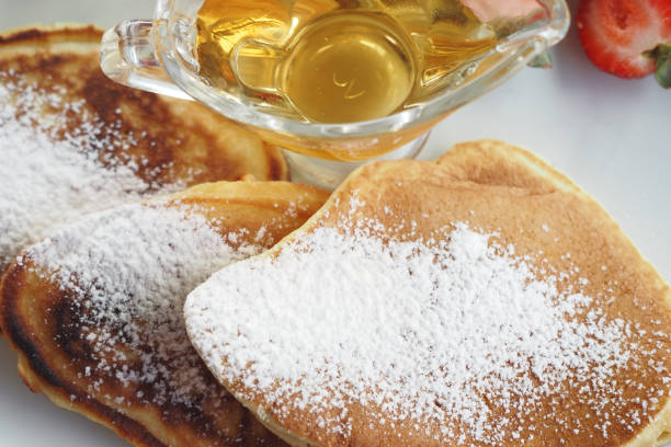 Fluffy pancakes pile with syrup on a blue plate and blurry background taste breakfast or lunch