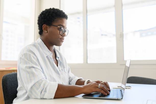 istock African-American female office employee using laptop 1988306808