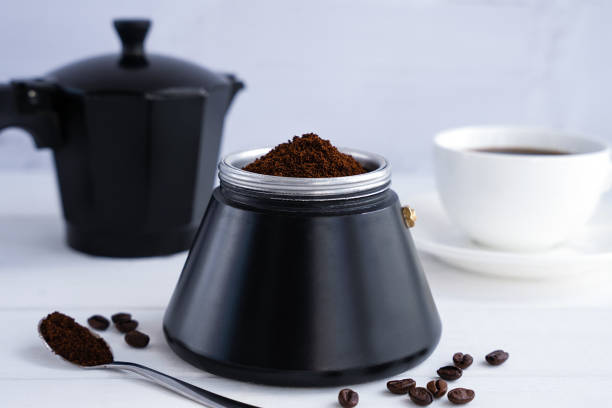 istock Freshly ground aromatic coffee in a geyser coffee maker on a white background. The concept of preparing natural coffee. Selective focus. 1988325440