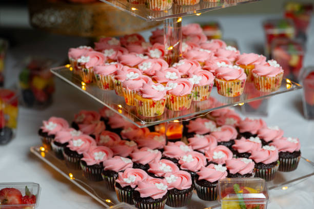 istock Birthday cupcakes on three tiered glass display stand festive pink 1988325952