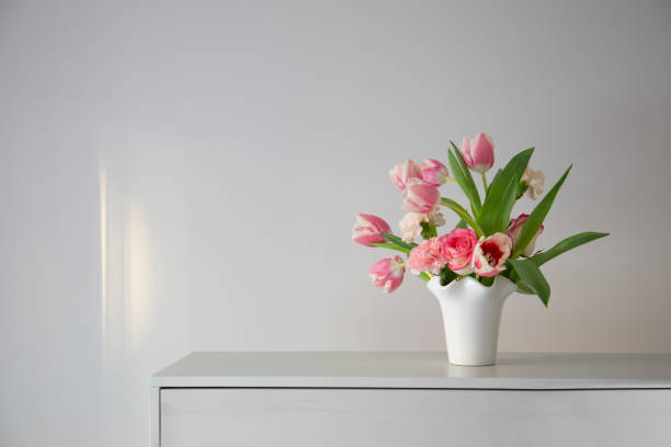 istock pink spring flowers in white ceramic vase in modern home interior 1988326996
