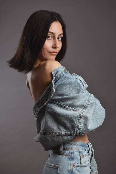istock Female Showing Bare Shoulders Underneath Denim Jacket 1988337933
