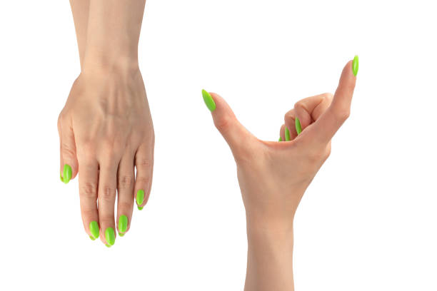 istock Hand of a woman with green naols hold some tiny or thin object. 1988343606