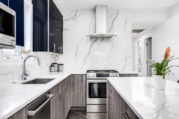 istock A modern kitchen with blue and wood cabinets and a white marble countertop. 1988351014