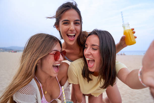 istock Three female friends with smoothies in summertime having fun. 1988356223