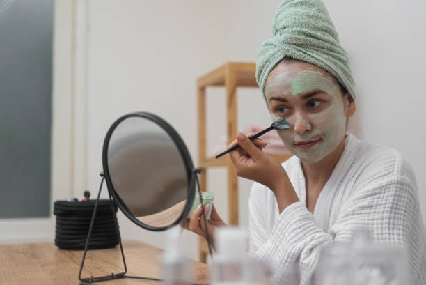 istock Skincare Retreat: beauty apply clay mask, admiring her reflection during 1988360406