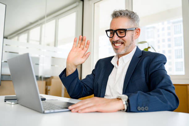 istock Mature gray-haired 60 businessman using laptop for video connection 1988363994