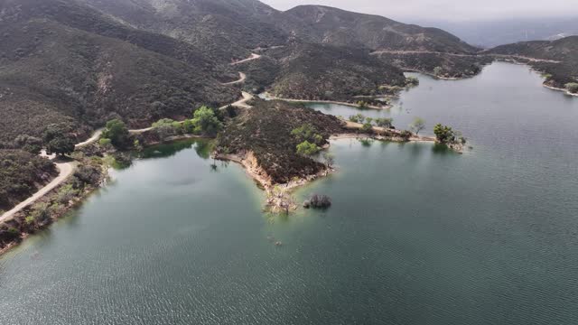 small island on Bouquet Reservoir in santa clarita Southern California on a moody day AERIAL TRUCKING PAN 60fps