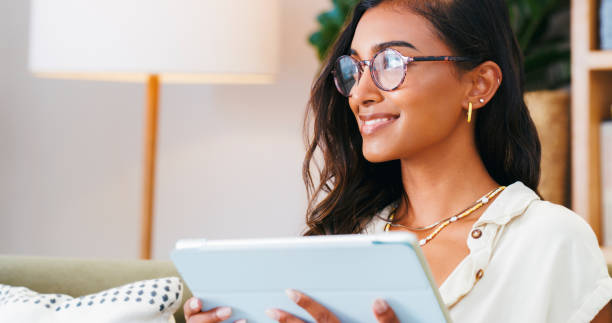 casa, pensamento e mulher com um tablet, decisão e escolha com mídias sociais ou aplicativo digital. pessoa, apartamento ou menina em um sofá ou tecnologia com ideias ou planejamento com conexão ou brainstorming - relaxation working humor sofa - fotografias e filmes do acervo